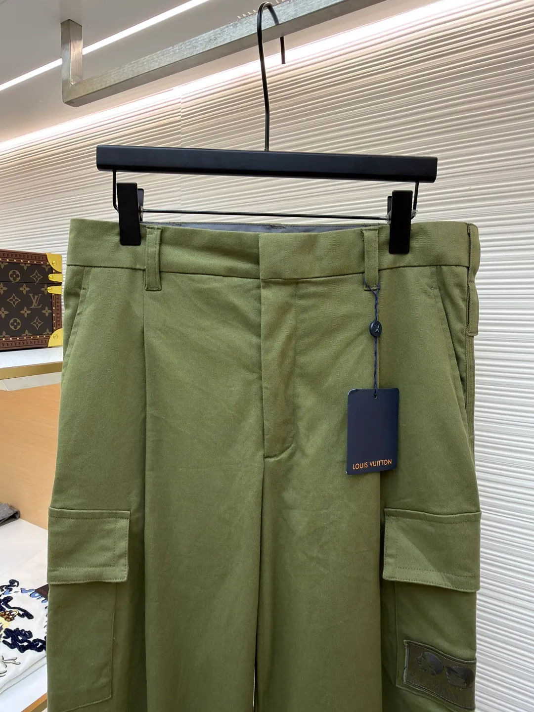 LOUIS VUITTON portrait embroidered work trousers ●Item number: 1681219-B65 ●Material: cotton twill fabric ●Technology: embroidery production ●Color: green ●Version: fitted version ●Weight: about 655 grams ●Size: 44-46-48-50 ●Description: The high cotton content ensures the fabric's excellent breathability, durability and classic workwear texture, while the twill weave gives it unique wear resistance and stiffness. The special fabric technology solves the pain points of tight and stiff traditional overalls; it provides greater freedom when moving, significantly improves wearing comfort and flexibility, and achieves a balance between function and comfort. For the embroidered portrait patch on the left, the portrait is digitally processed and converted into a line drawing blueprint that can be embroidered. A high-precision computer embroidery machine is used to perform multi-layer embroidery, and the outline, light and shade and texture details of the portrait are created by interweaving and superimposing embroidery threads of different colors. Tens of thousands of stitches and fine color transitions ensure clear lines and no unnecessary threads, making the portrait lifelike and three-dimensional. The design of the trousers combines retro workwear genes with modern deconstruction. The core lies in the neat pleat processing, which not only deconstructs the flat silhouette of the front, increases the three-dimensional sense and design level, but also visually optimizes the leg lines. Multiple flap pockets are classic workwear functional elements and the overall tough style. The overall wiring is straight and delicate, the fabric is comfortable and soft, and the color is consistent without color difference. It can be matched with the same style to create a fashionable look and control various occasions. Customized accessories, complete with three standards, same style for men and women!